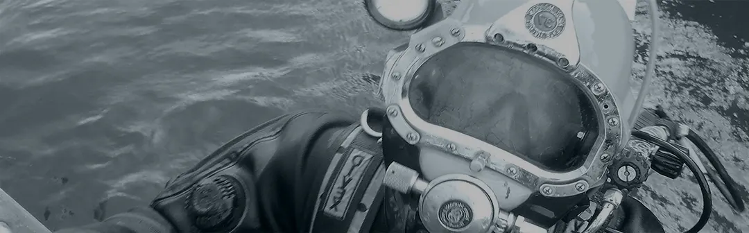Duiker van B&L met duikhelm aan het wateroppervlak
